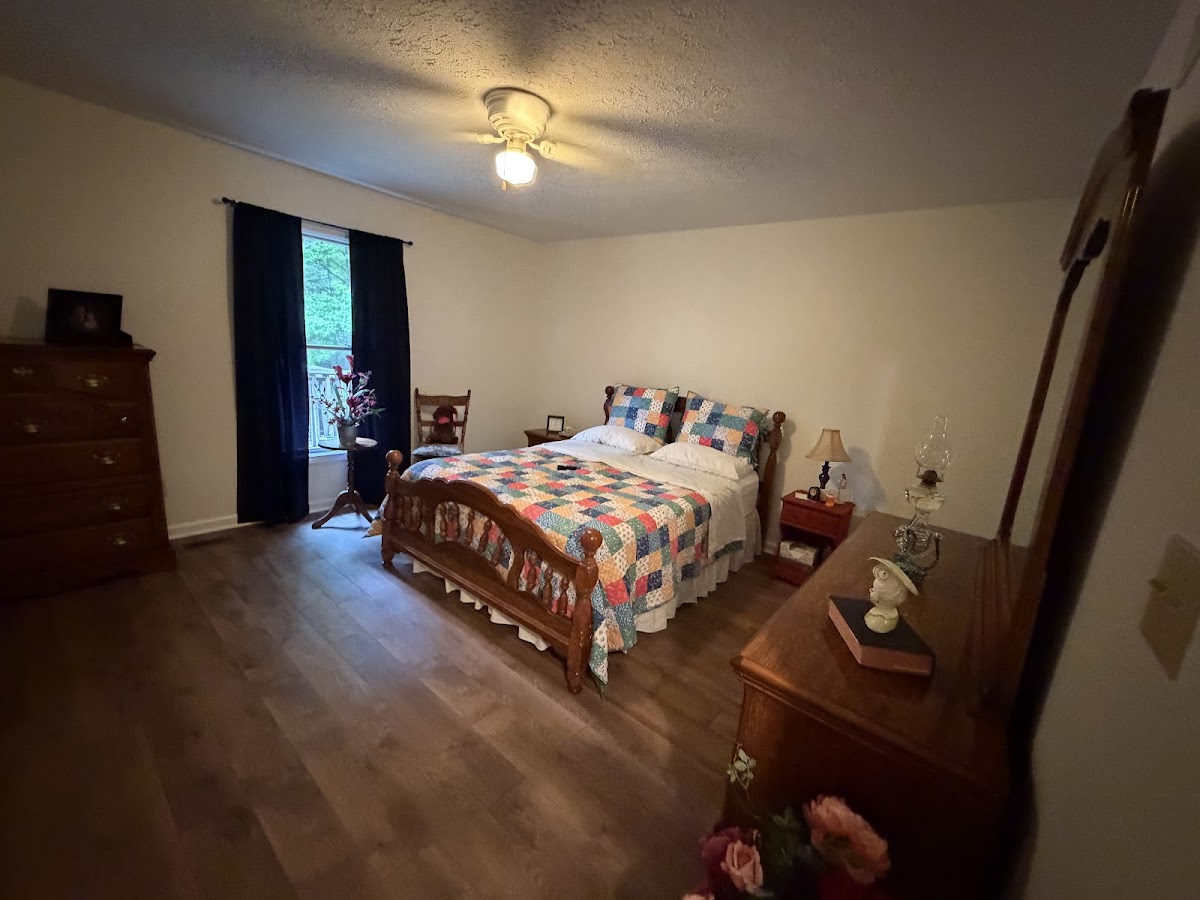 Bedroom with new flooring, painted walls, and a ceiling fan
